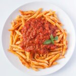 Penne all'Arrabbiata: Italian pasta with fiery tomato sauce, garlic, red chili peppers, and olive oil. A classic, bold dish.